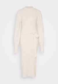 Strikket kjole i off-white med lange ermer, høy hals og beltedetalj i midjen, med en tætsittende silhuett.