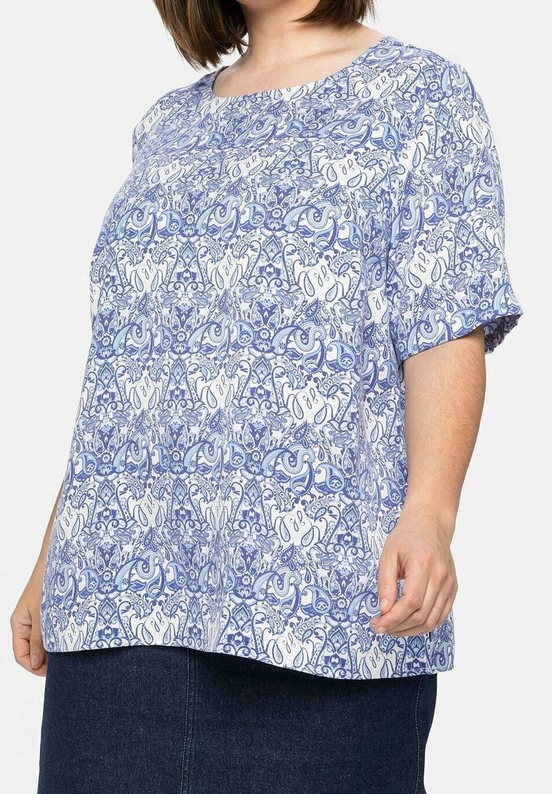 Leichtes blaues Kurzarmoberteil mit einem weißen und blauen filigranen Paisleymuster, Rundhalsausschnitt und einer lockeren Passform.