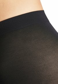 Zwarte ondoorzichtige panty’s met een gladde textuur, voorzien van een stevige elastische tailleband. Het materiaal is dun en licht glanzend.