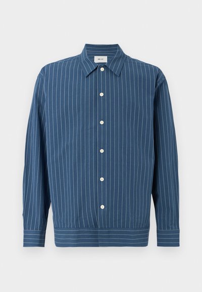 Chemise bleue à manches longues avec boutons, rayures verticales blanches, col pointu et ourlet large à rayures horizontales en bas.