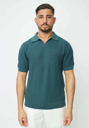 Polo-shirt teal foncé à manches courtes, texture côtelée et design en V. Présente un col contrasté et une taille ajustée.
