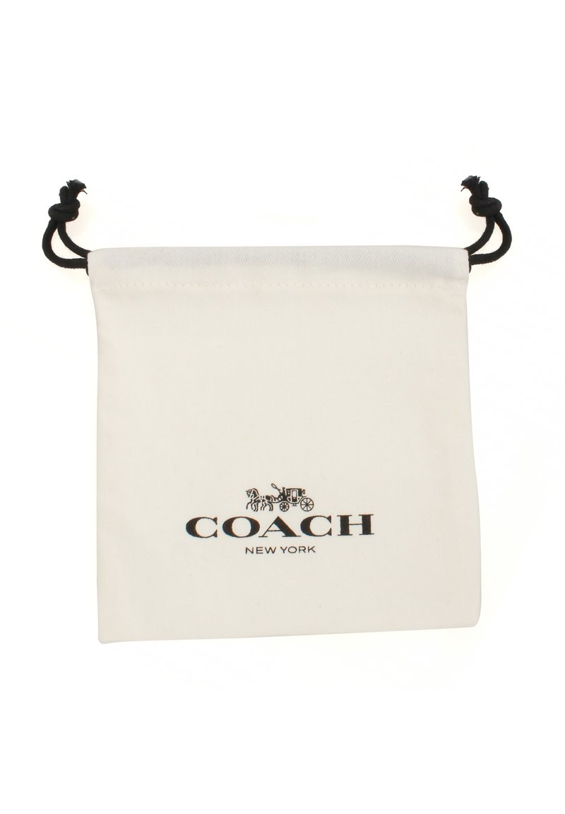 Funda de algodón blanca con cierre de cordón, que presenta el logotipo impreso en negro "COACH NEW YORK" y un diseño de carroza tirada por caballos. Textura suave.