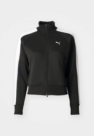 Veste zippée noire avec col haut, présentant des accents de panneaux latéraux blancs et un petit logo blanc sur la poitrine. Poignets et ourlet côtelés.