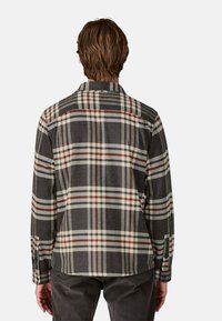 Camicia a quadri grigia con motivi beige e rossi, maniche lunghe, colletto a punta e polsini con bottoni. Realizzata in un tessuto testurizzato.