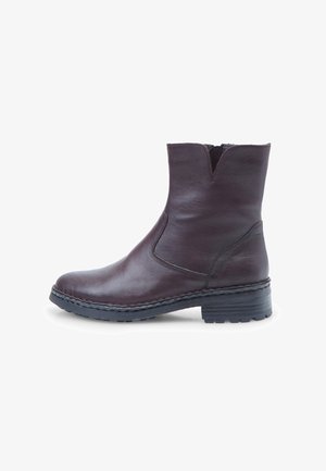 Botine cu toc din piele maro, cu detalii cusute, panouri elastice pe laterale și talpă din cauciuc texturat. Toc întreg pentru o stabilitate mai bună.