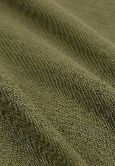 Tissu tricoté vert olive avec une texture fine, présentant des motifs diagonaux subtils et un drapage doux. Idéal pour des applications vestimentaires.