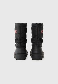 Botas impermeables negras con parte superior acolchada, puños elásticos y suelas de goma. Presenta acentos de logo rosa en los laterales.