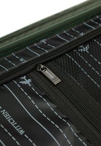 Schwarzer Koffer mit Innenfächern, die beschriftet sind, einem Reißverschluss-Zipper, der mit "WITTCHEN" gekennzeichnet ist, sowie weißen genähten Linien und Flugzeug-Icons.