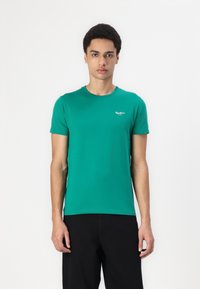 Green cotton t-shirt with a crew neck, short sleeves, featuring a small white logo on the left chest. The fit is casual and regular.