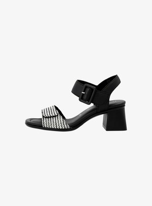 Sandali con tacco bianco e nero con cinturino a fibbia, con un design a scacchi testurizzati sul davanti e un tacco quadrato.