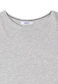 Pullover in cotone grigio chiaro con scollatura rotonda e dettagli a coste. L'etichetta riporta "CECIL." Il tessuto ha una consistenza liscia.