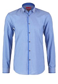 Chemise habillée homme à manches longues bleu clair avec un liseré bleu foncé contrastant le long de la patte de boutonnage, à l’intérieur du col et aux poignets, boutonnée à l’avant.