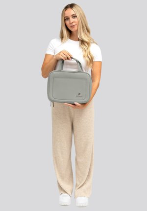 Borsa rettangolare grigia con doppie maniglie, dotata di una tasca frontale e un branding discreto. Materiale liscio con un design minimalista.