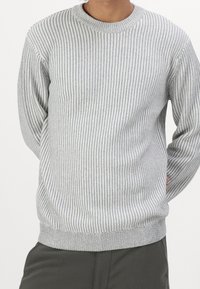 Pull en maille gris rayé avec des manches longues, un col rond et une texture côtelée aux poignets et à l'ourlet. Motif subtil sur l'ensemble du tissu.
