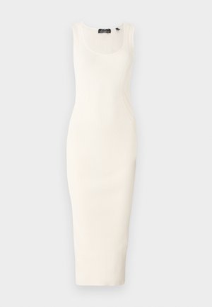 Ribbed, bezrukávové midi šaty v off-white farbe s priliehavým strihom. Obsahuje výstrih v tvare lukov a jemné zakrivené ševy.