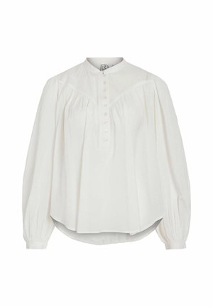 Vit blus med lång ärm, hög krage och knäppning framtill. Har rynkad tygdetalj vid axlarna och rundad nederkant. Tillverkad av lätt material.