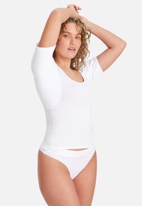 White fitted t-shirt with short sleeves, wide round neckline, and smooth texture. Paired with white minimalistic underwear, displaying skin.