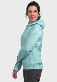 Light blue, waterproof jacket with a hood, featuring a zippered front, elastic cuffs, and a cinched hem for a secure fit.
