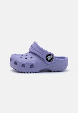 Purple rubber clog with ventilation holes, textured sole, and a back strap. Features a circular logo on the side. Lightweight design.