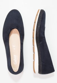 Námořnické semišové slip-on boty s měkkým interiérem, černý glitterový akcent podél paty a lehká gumová podešev. Plochý, zaoblený design špičky.