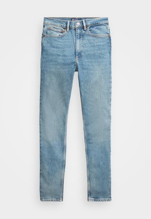 Šviesiai mėlyni džinsai su tiesiomis kojomis, turintys penkias kišenes, sagą uždarymui ir matomus siūlus palei siūles.