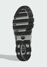 Schwarze und graue Sneaker-Sohle mit einem strukturierten Muster, hervorgehobenen Dämpfungs-Pods und einer zentralen Öffnung für Stabilität.