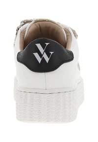 Sneaker bianco con una suola piatta texturizzata bianca, accentato da un tallone nero e un interno beige chiaro. Presenta un logo nero sul retro.