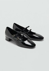 Pantofi Mary Jane din piele lac neagră, cu vârf pătrat, toc bloc jos și două barete reglabile cu catarame aurii. Finisaj neted, lucios.