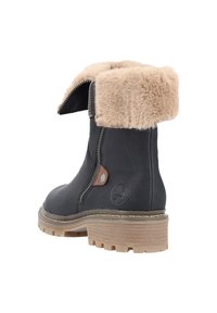 Bottine en cuir noir avec col en fausse fourrure beige, fermeture éclair latérale et semelle en caoutchouc avec crampons. Présente un petit logo et un accent en cuir.