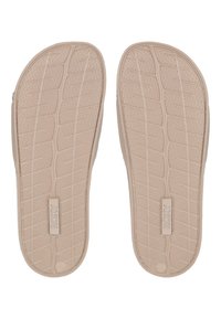 Kerman flip-flop pohjat, joissa on teksturoitu kuvio, keskellä logo. Pohjat on valmistettu joustavasta kumimateriaalista ja niissä on uritettu pito.
