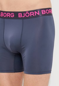 Μαύρες μποξερ σλιπ Björk Borg σε σκούρο γκρι χρώμα με ροζ λάστιχο στη μέση. Υπέροχο, ελαστικό υλικό και εφαρμοστή γραμμή με ραφές.