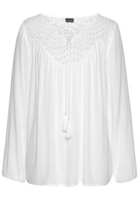 Blouse blanche en tissu léger, ornée d'un yoke décoratif à pois, avec des manches longues et une fermeture à nouer avec des pompons au niveau du col.