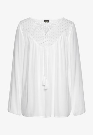 Witte blouse van lichtgewicht stof, met een decoratief yoke met stippen, lange mouwen en een sluiting met koord en kwastjes bij de halslijn.