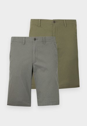 Two pairs of shorts in green and olive colors. Both have a smooth texture, button closures, and flat front design. No visible patterns.