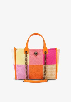 Borsa a tracolla patchwork colorata con manici in pelle arancione, motivi floreali sui quadrati di tessuto e una catenella dorata con un emblema decorativo a forma di teschio.
