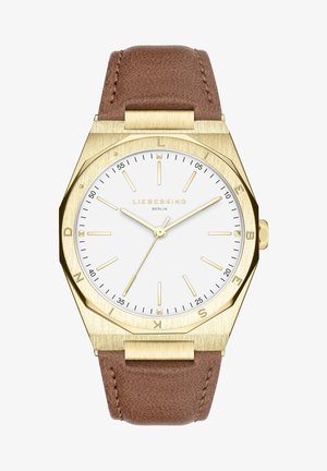Montre-bracelet en ton or avec cadran blanc, index des heures dorés minimalistes, bracelet en cuir marron et nom de la marque "Liebeskind Berlin" sur le cadran.