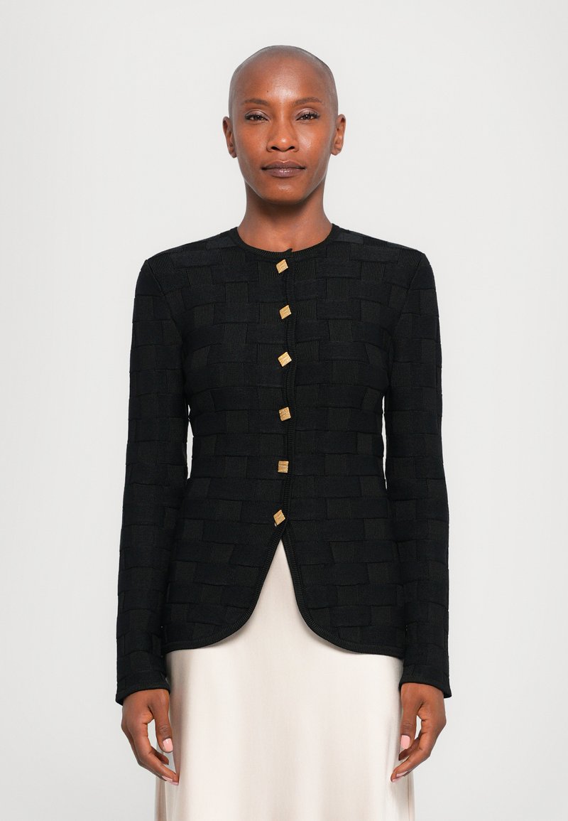 Black textured jacket featuring woven pattern, round neckline, and gold-tone buttons. Tailored fit with a curved hem. Long sleeves.