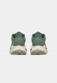 Grüne Laufschuhe mit strukturiertem Mesh-Obermaterial, weißer Zwischensohle und Gummilaufsohle. Verfügt über sichtbare Fersenpolsterung und Markenakzente.