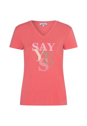 Korallenfarbenes T-Shirt mit kurzen Ärmeln und V-Ausschnitt, vorne mit übereinanderliegenden "SAY YES"-Schriftzügen in Hellrosa, Beige und Braun.