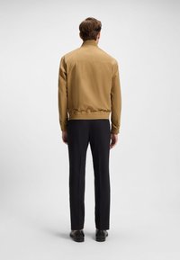 Taan kerge jope soonikkoes krae ja mansettidega, elastse vöökohaga, sobitatud kohandatud mustade pükstega ja tumedate kingadega.