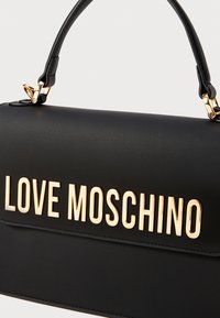 Black handbag made of smooth leather, featuring a structured shape and a top handle. Gold "LOVE MOSCHINO" logo is prominently displayed on the front.