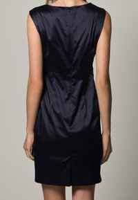 Mörkblå satin klänning utan ärmar med en figurnära passform, som har en dragkedja bak och en subtil slits i fållen för lätt rörelse.