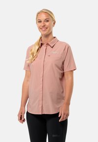 Camicia a maniche corte con bottoni di colore rosa chiaro, realizzata in tessuto testurizzato. Presenta una tasca sul petto e un logo ricamato vicino al colletto.