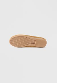 Brown suede shoe outsole with a textured, rubber-like tan sole featuring a honeycomb pattern and a smooth accent near the heel.