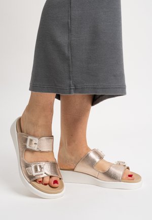 Metallisch rosa-goldfarbene Sandalen mit zwei verstellbaren Riemen und Schnallen, ausgestattet mit gepolstertem beigefarbenem Fußbett und einer weißen Plateau-Sohle.