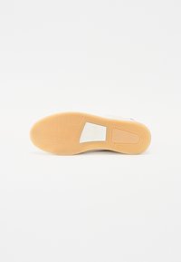 Sneakersåle med et fiskebensmønster, med en hvit gummibase og en tan-farget gummisåle. Glatt finish med støpte detaljer.