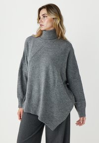 Szary, oversize sweter z wysokim kołnierzem, prążkowanymi mankietami i asymetrycznym zakończeniem. Wykonany z miękkiego, teksturowanego materiału.