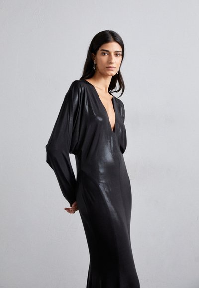 Abito nero a maniche lunghe con scollatura profonda e design aderente. Realizzato in tessuto lucido, presenta maniche drappeggiate e una silhouette elegante.