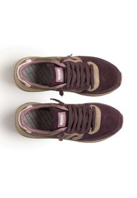 Un paio di sneakers in suede viola e beige con lacci, vista dall'alto, che mostra l'etichetta del marchio sulla linguetta e le soletta a motivi.