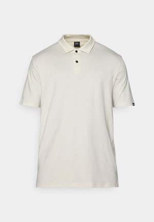 Koszulka polo z krótkim rękawem w jasnym beżowym kolorze, wykonana z bawełny, z klasycznym kołnierzykiem, zapięciem na trzy guziki oraz małym logo na lewym rękawie.